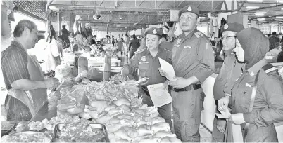  ??  ?? PEGAWAI KPDNKK Sibu diketuai Ganda melakukan pemantauan harga di salah sebuah gerai menjual ayam segar di Pasar Sentral Sibu.