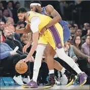  ??  ?? THE KNICKS’ Mitchell Robinson, right, tightens his defense against the Lakers’ Anthony Davis.