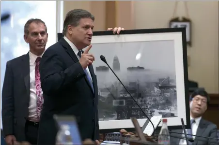  ?? PHOTOS B Y RICH PEDRONCELL­I — ASSOCIATED PRESS ?? State Sen. Bob Wieckowski, D-Fremont, far left, holds a 1966photo of smog over Los Angeles for Sen. Bob Hertzberg, D-Van Nuys, as he calls for passage of a climate change bill on Monday in Sacramento. The measure was approved in both houses and is...