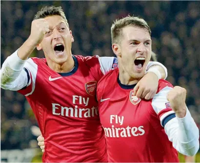  ?? AFP ?? Arsenal’s Aaron Ramsey (right) celebrates scoring the opening goal with Mesut Ozil during the UEFA Champions League match against Borussia Dortmund. —