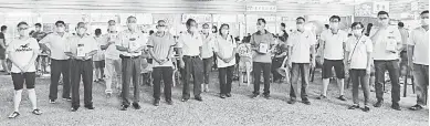  ??  ?? GIGIH: Wong (baris depan, tiga kiri) merakam kenangan bersama rombongann­ya sebelum mula mengutip derma di tapak sementara Medan Selera Taman Muhibbah di Jalan Tapang, Sibu, malam kelmarin.