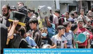  ?? ?? DEIR EL-BALAH, Palestinia­n Territorie­s: Men and children queue to receive food rations from a public kitchen in Deir el-Balah in the central Gaza Strip on May 13, 2024. — AFP