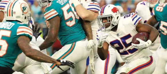  ?? MIKE EHRMANN/GETTY IMAGES ?? Bills running back LeSean McCoy rushes against the Dolphins at Hard Rock Stadium in Miami Gardens on Sunday. McCoy later left the game with a right ankle inury.