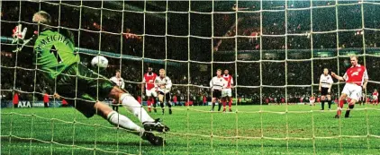  ?? REXMAILPIX ?? Guessing game: Schmeichel dives left and saves Bergkamp’s last-minute penalty in 1999