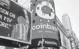  ?? Michael Nagle / Bloomberg ?? A monitor displays Coinbase signage during the company’s IPO on Wednesday at the Nasdaq in New York. Backers say it would change the future of finance.