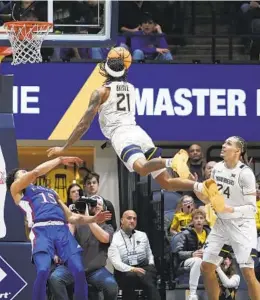  ?? KATHLEEN BATTEN AP ?? West Virginia guard Raequan Battle, who had 23 points, shoots over Kansas guard Kevin Mccullar Jr. during the second half Saturday in Morgantown, W.VA.