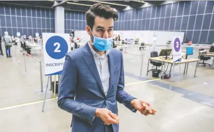  ?? JOHN MAHONEY ?? Dr. Louis-xavier D'aoust gives media a tour of the CIUSSS Centre-sud's new mass vaccinatio­n clinic at the Palais des Congrès Monday.