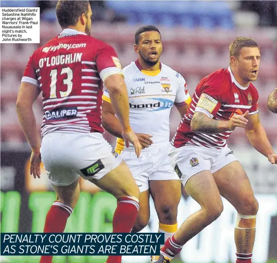  ??  ?? Huddersfie­ld Giants’ Sebastine Ikahihifo charges at Wigan Warriors’ Frank-Paul Nuuausala in last night’s match. Pictures by John Rushworth