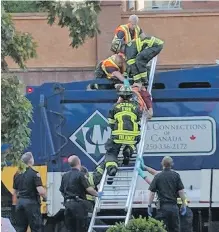  ??  ?? Emergency crews work to extract the man who was found in the compactor of a garbge truck on Wednesday.