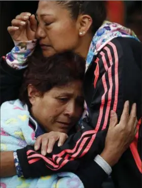  ?? REBECCA BLACKWELL — THE ASSOCIATED PRESS ?? Roberta Villegas, the mother of her missing son Paulino Estrada, left, is embraced by family member Itzel Melendez, as they wait for news outside a quake-collapsed sevenstory building where Estrada is believed to be trapped, in Mexico City’s Roma Norte...