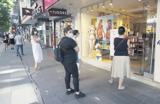  ??  ?? People wear face masks and keep a social distance outside a clothing shop in Ankara, Turkey, July 4, 2020.