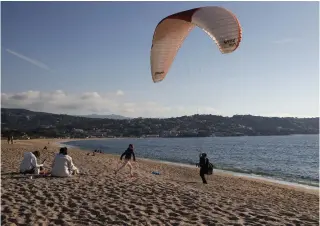  ?? Photo by Pascal POCHARD-CASABIANCA / AFP ?? A man tests the a paraglider along the beach during a warm weekend on the French Mediterran­ean island of Corsica, in Porticcio on February 18, 2024.