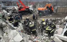  ?? Belgorod Region Governor Vyacheslav Gladkov/Telegram channel via AP ?? Emergency ministry employees work Monday at a destroyed building after shelling from the Ukrainian side, in Nikolskoye village, Belgorod region, Russia.