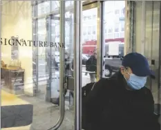  ?? AP PHOTO/YUKI IWAMURA ?? A person leaves one of the Signature Bank branches in New York, on Monday.