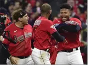  ?? PHIL LONG – THE ASSOCIATED PRESS ?? The Guardians' Oscar Gonzalez, right, and Josh Naylor, left, celebrate with Amed Rosario after Saturday's comeback win.