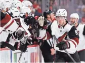  ??  ?? Coyotes right wing Clayton Keller high-fives teammates after scoring during the first period Sunday against the Red Wings in Detroit.