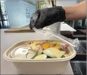  ?? ?? An individual­ly wrapped plastic fork is placed with a takeout salad at LJ's Deli.