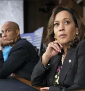  ?? J. SCOTT APPLEWHITE — THE ASSOCIATED PRESS ?? Sen. Kamala Harris, D-Calif., and Sen. Cory Booker, D-N.J., left, pause as protesters disrupt the confirmati­on hearing of President Donald Trump’s Supreme Court nominee, Brett Kavanaugh, on Capitol Hill in Washington, Tuesday.