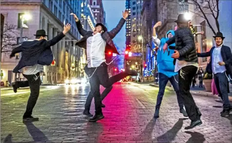  ?? Alexandra Wimley/Post-Gazette ?? Yeshiva school students dance on Grant Street on Thursday after the menorah lighting outside of the City-County Building, Downtown, for the fifth night of Hanukkah.