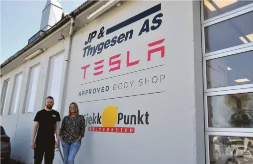  ??  ?? VELKOMMEN: Kundemotta­ker Åshild Terjesen og deleansvar­lig Eivind Valborglan­d ønsker velkommen til Tesla-verksted i Lillesands­veien. Den nye teksten på veggen er ikke helt ferdig malt.