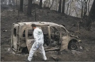  ?? Lalo R. Villar / Associated Press ?? A forensics officer inspects the remains of a vehicle where two women died in a fire in Pontevedra, Spain.