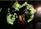  ?? Photograph: Hannah McKay/Reuters ?? Metropolit­an police officers detain a woman during a vigil for Sarah Everard on Clapham Common in March 2021.