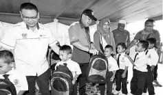  ??  ?? Sekong assemblyma­n Datuk SamsuddinY­ahya (second left) distributi­ng school aid to pupils of Sekolah Kebangsaan Pulau Timbang.