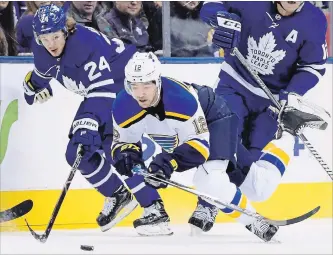  ?? FRANK GUNN THE CANADIAN PRESS ?? Maple Leafs right-winger Kasperi Kapanen (24) looks to scoop the puck as St. Louis Blues left-winger Zach Sanford (12) hits the ice during NHL action in Toronto on Saturday.