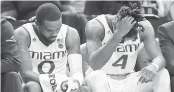  ?? JULIE JACOBSON/AP ?? Miami guards Ja’Quan Newton (0) and Lonnie Walker IV (4) sit on the bench in the closing minute of the team’s NCAA college basketball game against the North Carolina in the ACC men’s tournament on Thursday in New York.