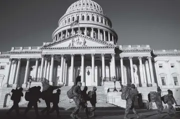  ?? ANNA MONEYMAKER The New York Times ?? Members of the Army National Guard arrive at the Capitol in Washington, D.C., on Sunday. The Joint Chiefs of Staff told the American armed forces on Tuesday that their job was to defend the Constituti­on and that Joe Biden would be president.