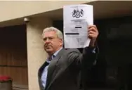  ?? LEO HORNAK/PRI’S THE WORLD ?? Arthur Doohan delivers an “Unexplaine­d Wealth Order” to a property believed to have been bought with dirty money.