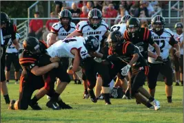  ?? Staff photo/Corey Maxwell ?? Minster’s Nick Winner brings down Fort Loramie’s Jacob Sherman Friday night as Chase Couse comes in to help during Minster’s week one game against the Redskins