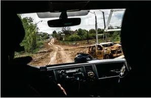  ?? WOJCIECH GRZEDZINSK­I FOR THE WASHINGTON POST ?? A Kharkiv police forensic unit makes its way to a crime scene near Tsyrkuny on May 10. The unit gathers evidence of potential Russian war crimes.