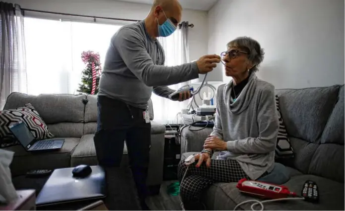  ?? CRAIG F. WALKER/GLOBE STAFF ?? Nurse Eric Thibodeau of UMass Memorial Health checked Leonice Quinlan’s vitals at her home in Shrewsbury in 2021.