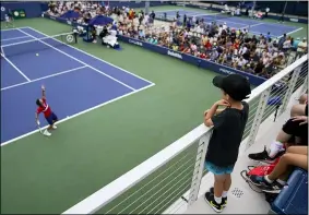  ?? JOHN MINCHILLO — THE ASSOCIATED PRESS ?? Fans watch Ricardas Berankis serves to Diego Schwartzma­n during the first round of the U.S. Open on Aug. 30 in New York.