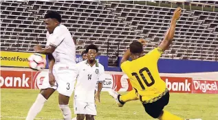  ?? FILE ?? Jamaica’s Romario Williams (right) volleys a shot past Suriname’s Joel Baja (left) and Sergio Eduard during their CFU Caribbean Cup qualifier at the National Stadium on Sunday, November 13, 2016.