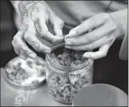  ?? AP/RICHARD VOGEL ?? A budtender weighs out marijuana for a customers at ShowGrow on April 15. Arkansas in some ways is playing catch-up. People have used marijuana’s medicinal properties for about 5,000 years at least, according to a 2013 report in the scientific journal...