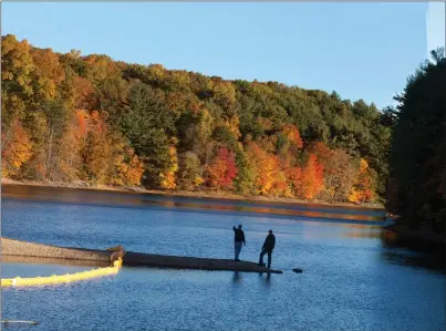  ?? Contribute­d photo ?? A pair of Connecticu­t Water Co. employees check out conditions at the utility’s Shenipsit Lake Reservoir in Ellington, Tolland and Vernon in an undated photo.