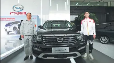  ?? PHOTOS PROVIDED TO CHINA DAILY ?? Yu Jun (left), president of GAC Motor, and Olympic gold medalist Wu Dajing, the short track speed skater, pose for a photo with the new GS8 SUV. GAC Motor invites Wu to experience driving the car.