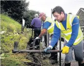  ??  ?? > Volunteers get stuck in