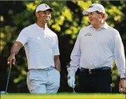  ?? CURTIS COMPTON / ATLANTA JOURNAL-CONSTITUTI­ON ?? Tiger Woods (left) and Phil Mickelson, who have combined to win 19 majors, share a laugh at the Masters last month.