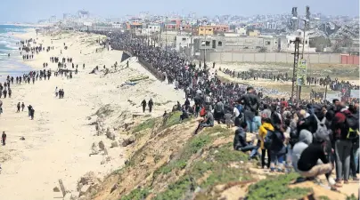  ?? ©REUTERS/MAJDI FATHI ?? Palestines­i sfollati percorrono la strada costiera vicino a Nuseirat, per rientrare a Gaza City.