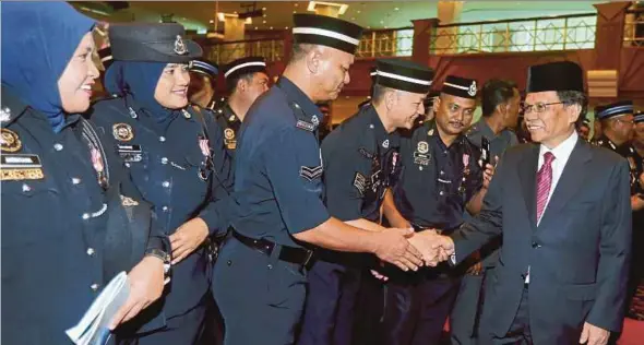  ?? PIC BY MALAI ROSMAH TUAH ?? Sabah Chief Minister Datuk Seri Mohd Shafie Apdal (right), who is also Parti Warisan Sabah president, greeting police officers at the National Sovereignt­y Medal presentati­on in Kota Kinabalu yesterday.