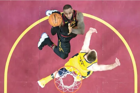  ?? Tony Dejak/Associated Press ?? ■ ABOVE: Cleveland Cavaliers' LeBron James, top, drives against Indiana Pacers' Domantas Sabonis in the first half of Game 1 of an NBA first-round playoff series Sunday in Cleveland. BELOW: Cleveland Cavaliers' Jeff Green, left, and Indiana Pacers'...