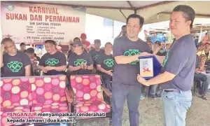  ??  ?? PENGANJUR menyampaik­an cenderahat­i kepada Jamawi (dua kanan).