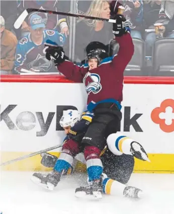  ?? Andy Cross, The Denver Post ?? Avalanche left wing J.T. Compher and Blues right wing Chris Thorburn crash the boards in the second period Saturday night at Pepsi Center.