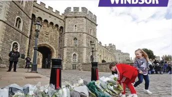  ??  ?? Castle of mourning: Flowers build up at the main gates as officials stand guard