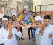  ?? HT FILE ?? Family members and volunteers carry an elderly voter to a voting centre in Kota during the last assembly election.