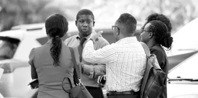  ?? PHOTO EDITOR RICARDO MAKYN/CHIEF ?? Staff of the Ministry of Education gather outside the multistore­y Heroes Circle headquarte­rs moments after a magnitude-7.7 earthquake shook Jamaica and several countries in the Americas.