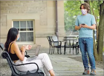  ?? Jason Koski Associated Press ?? BRYAN MALEY, right, a graduate student in the master of public health program at Cornell University in Ithaca, N.Y., interviews a student about her mask-wearing experience­s as part of a public health survey.